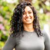 Mirjam, lid van het team van Connection SGGZ, staat vriendelijk lachend voor een hek.